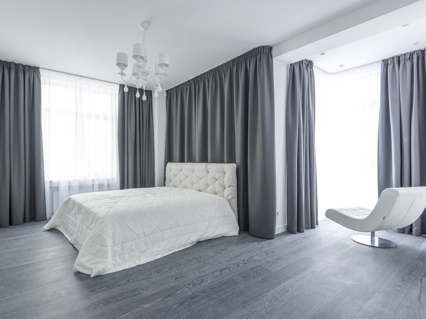 White Bed in a Bedroom With Gray Curtains