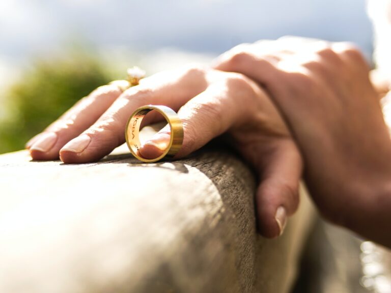person holding gold wedding band
